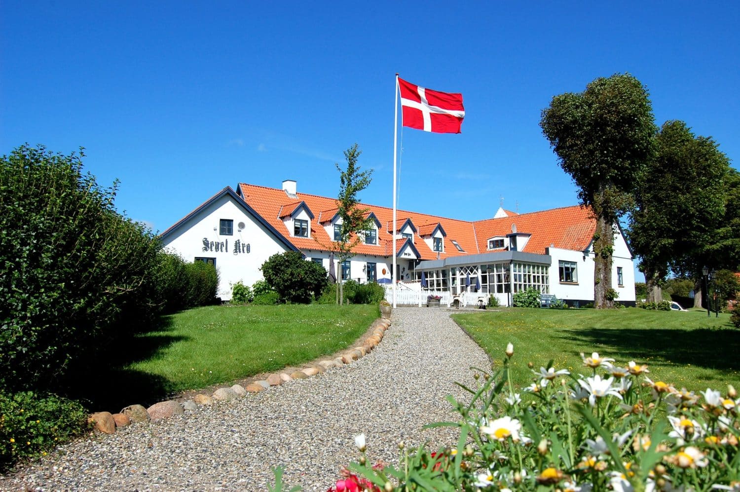 Sevel Kro, hvis historie kan følges tilbage 1700tallet, søger yngre kræfter. Sælger, der har været på stedet siden 1992, ønsker inden for det næste års tid at nyde sit otium på fuld tid. De senere år har kroen primært været drevet ved fremmed hjælp.
Kroen fremstår i flot stand med et stort køkken, restaurant, møde- og selskabslokaler fyldt med atmosfære og hygge, 5 værelser på 1. sal samt smukt haveanlæg og fine parkeringsforhold. Se mere på kroens hjemmeside.
Kroen, der er beliggende ved turistattraktionen Hjerl Hede er omkranset af skøn natur og gode jagt- områder. Beliggenheden er optimal som udgangspunkt for udflugter til midt- og vestjyske attraktioner. Sevel Kro er et populært midtpunkt for mange fester og arrangementer.
Grundarealet udgør 2.257 kvm. Bygningernes samlede etageareal er på 830 kvm.
Ønskes værelseskapaciteten udvidet kan en naboejendom med 4 hotellejligheder tilkøbes for kr. 795.000.
Fine regnskabstal kan dokumenteres. Overtagelse: Januar 2027 – eller efter aftale.
Forhør nærmere ved henvendelse til michael@bunzel.dk